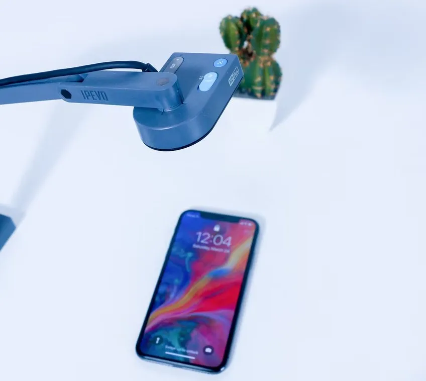 A phone being tested under a desk camera arm