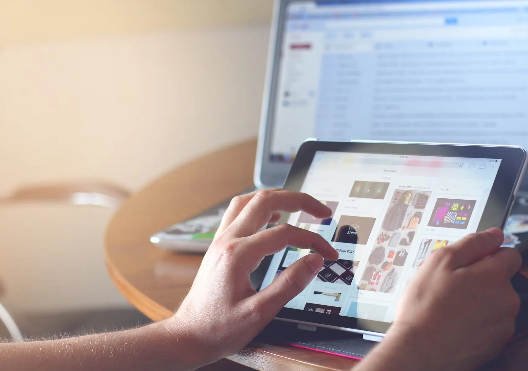 A designer browsing ProUX templates on a tablet in front of a laptop